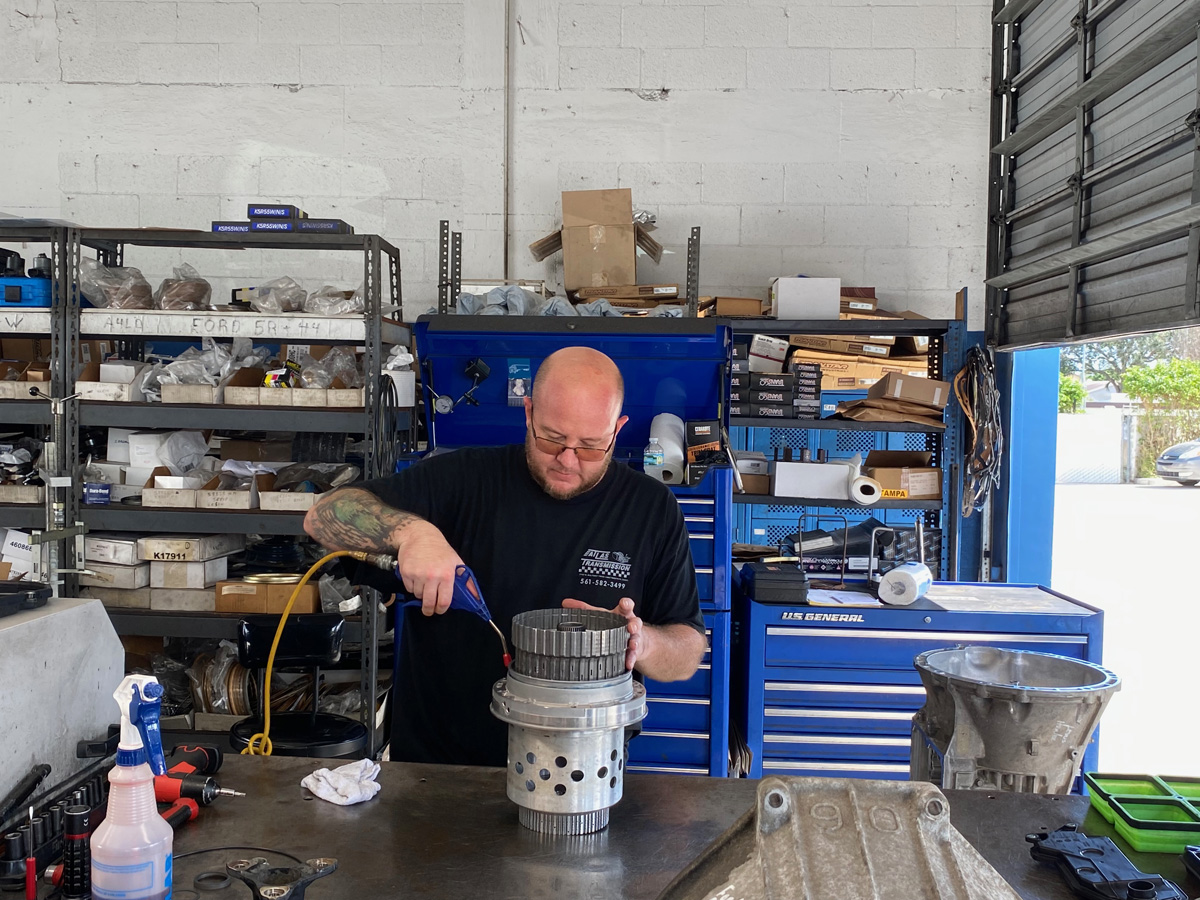 Mechanic repairing car part in garage workshop.