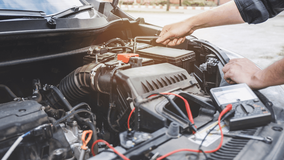 Mechanic working on car engine with tools